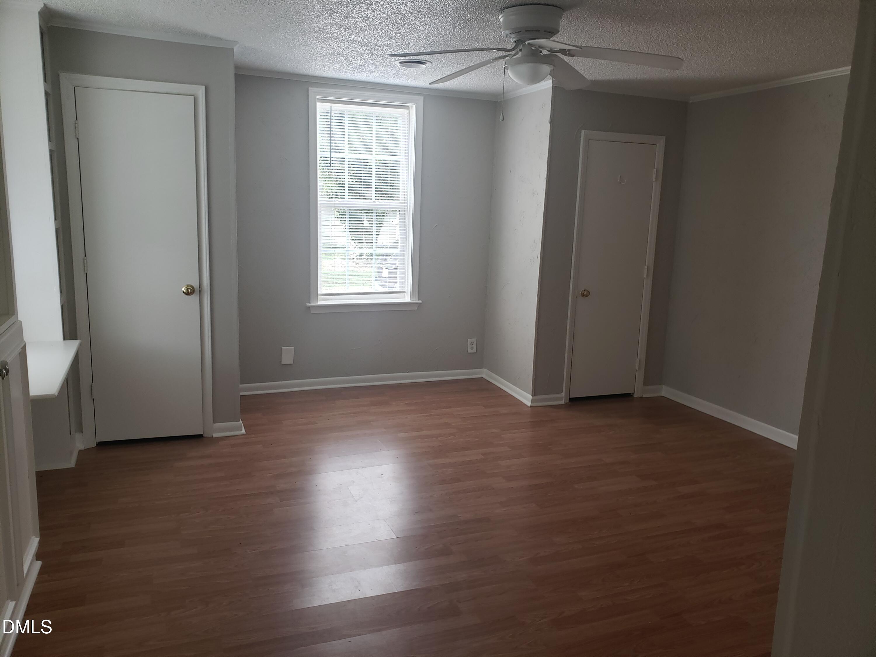 306 South Moore Street Clayton, NC 27520 - Photo 5 of 31 an empty room with wooden floor and windows
