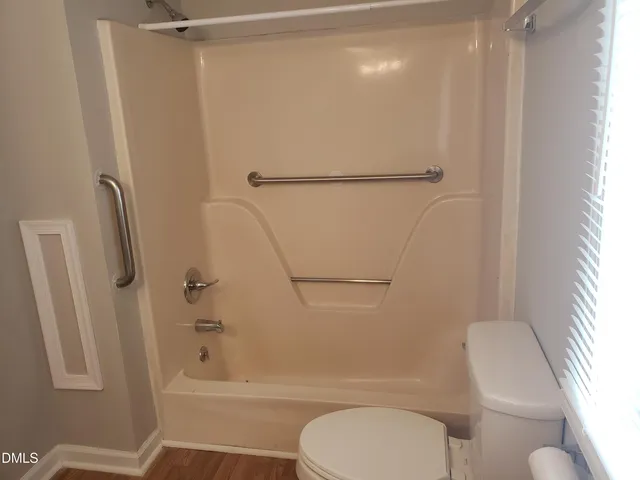 a bathroom with a toilet and a shower