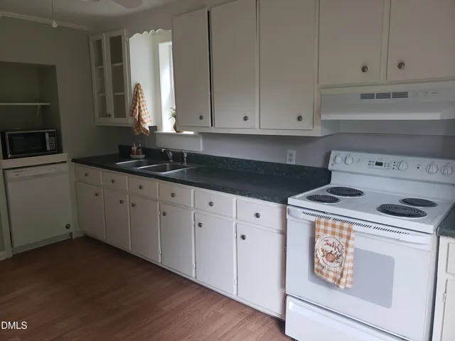 a kitchen with granite countertop white cabinets and a stove