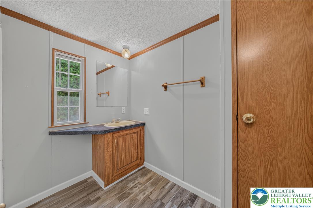 2674 Williams Road Danielsville, PA 18038 - Photo 25 of 31 A window-lit vanity with wood-grain cabinetry offers practical elegance in this functional bathroom.