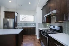 a kitchen with kitchen island granite countertop a sink stove and refrigerator