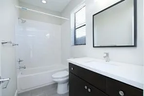 a bathroom with a sink a toilet a mirror and shower