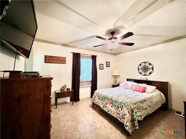 a bedroom with a bed and a ceiling fan