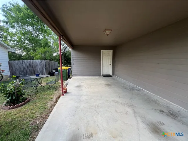 a view of a backyard with potted plants and wooden fence