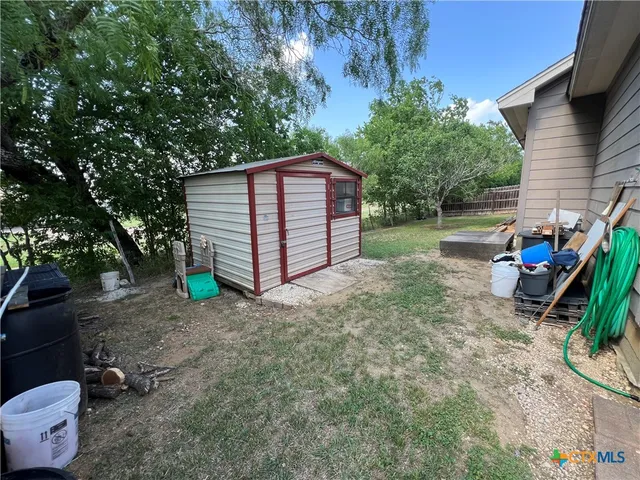 a view of backyard with wooden fence and trees