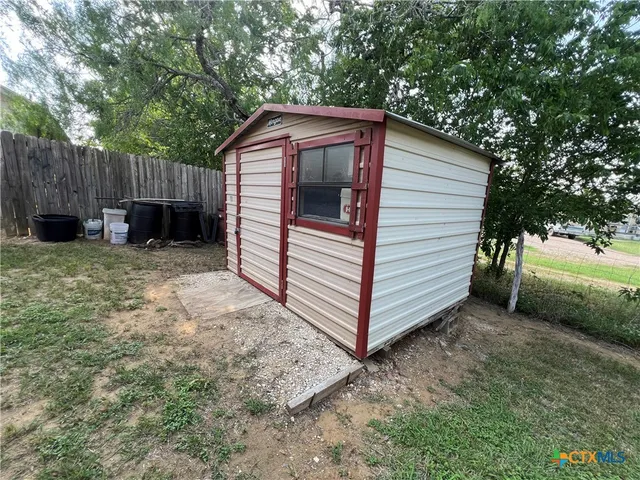 a view of a house with a yard and wooden fence