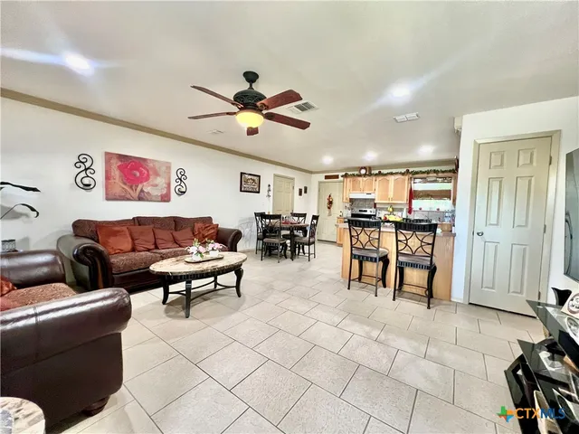 a living room with furniture and kitchen view