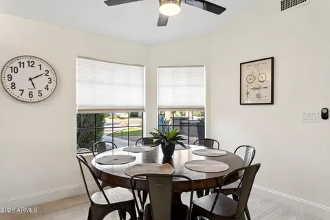 a view of a dining room and livingroom with furniture a rug a fireplace and a chandelier
