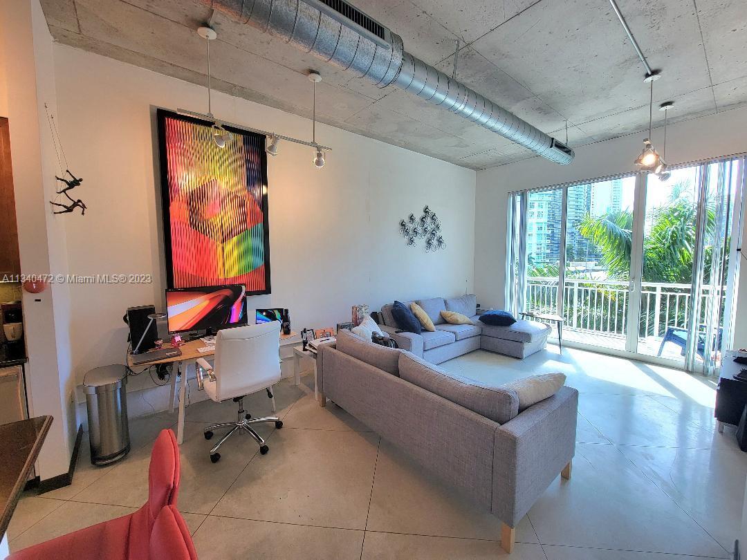 a living room with furniture and a floor to ceiling window