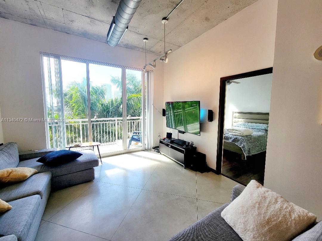 2001 Biscayne Boulevard, Unit 2505 Miami, FL 33137 - Photo 2 of 18 a living room with furniture and a flat screen tv