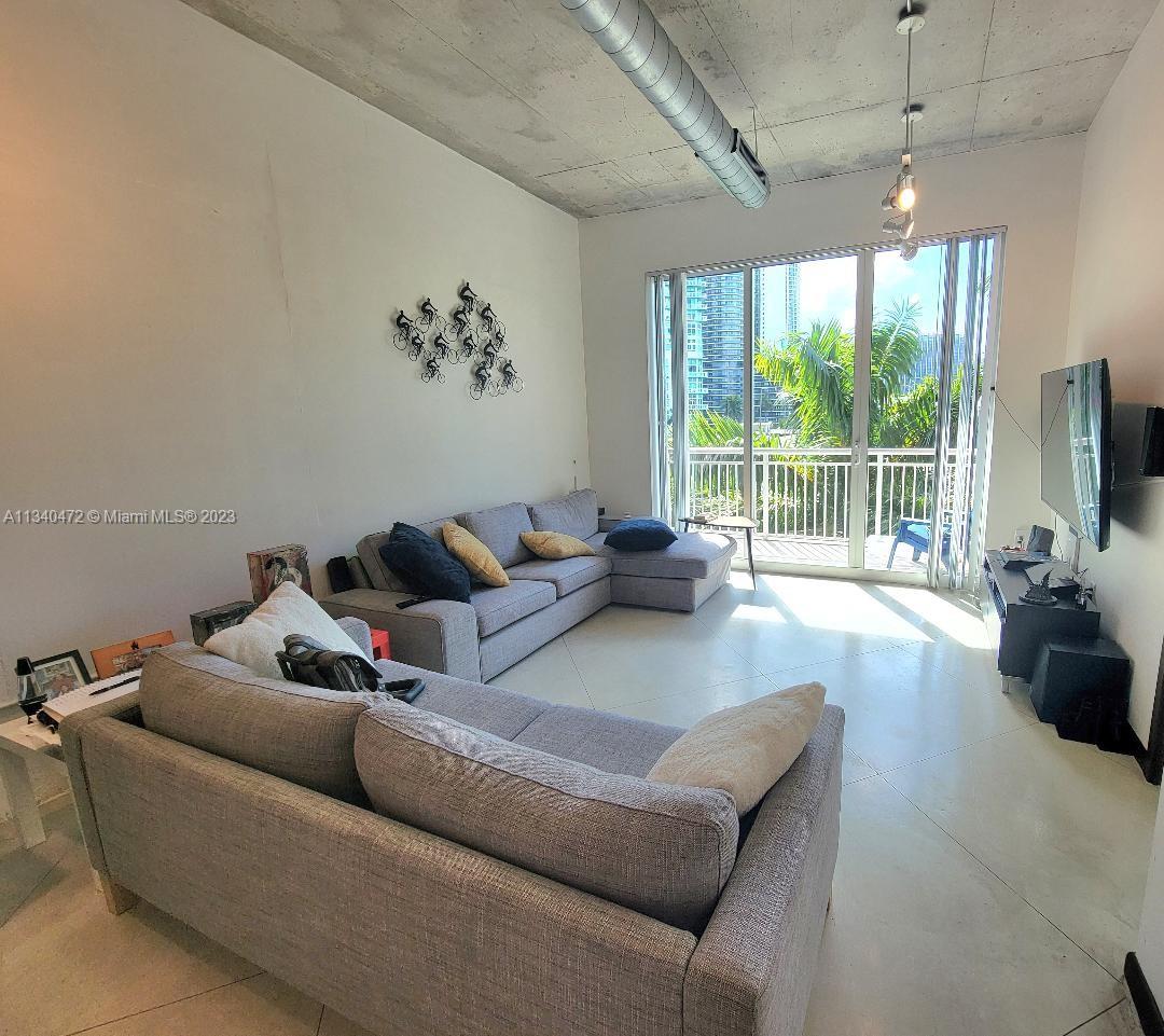 2001 Biscayne Boulevard, Unit 2505 Miami, FL 33137 - Photo 3 of 18 a living room with furniture and a flat screen tv