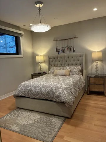 a bedroom with a large bed and a chandelier