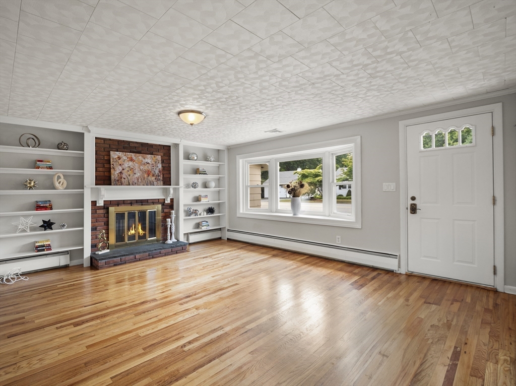 85 Dalton Road Chelmsford, MA 01824 - Photo 3 of 39 an empty room with wooden floor fireplace and windows
