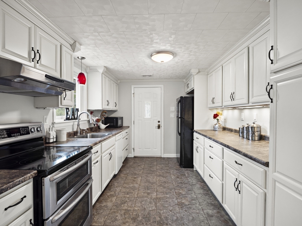 85 Dalton Road Chelmsford, MA 01824 - Photo 8 of 39 a kitchen with stainless steel appliances granite countertop a stove top oven a refrigerator a sink and dishwasher with white cabinets