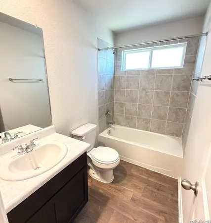 a bathroom with a sink a toilet a mirror and bathtub