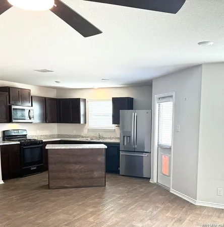 a kitchen with stainless steel appliances granite countertop a refrigerator and a stove