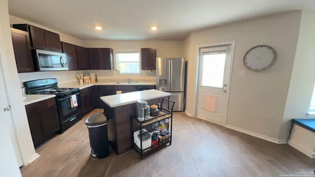 a kitchen with stainless steel appliances granite countertop a stove a sink and a microwave