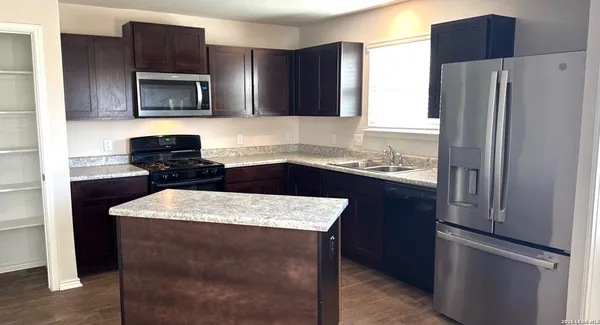 a kitchen with stainless steel appliances granite countertop refrigerator sink and microwave
