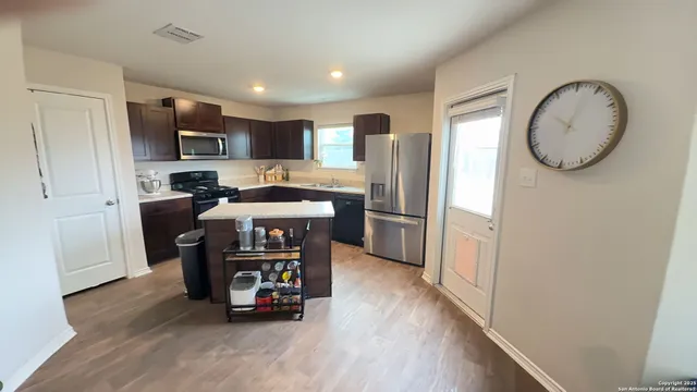 a kitchen with stainless steel appliances granite countertop a refrigerator a stove top oven a sink and dishwasher