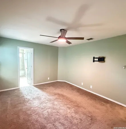 an empty room with ceiling fan and window