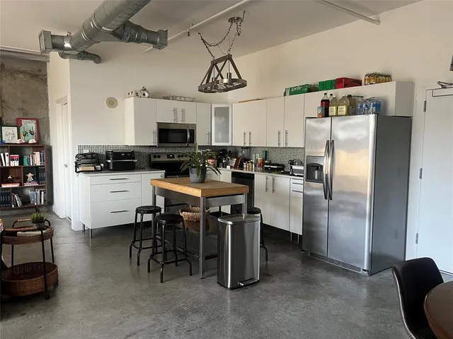 a kitchen with refrigerator and chairs