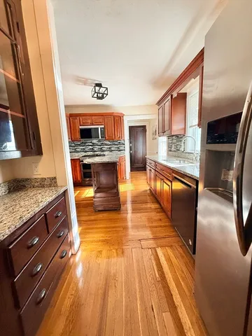 a kitchen with granite countertop wooden floors and a fireplace