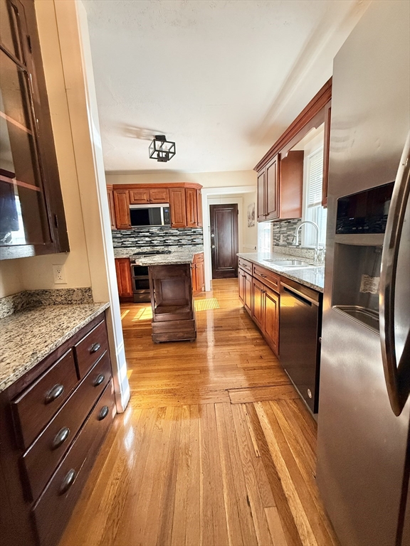 48 Rosewood Street, Unit 2 Boston, MA 02126 - Photo 20 of 26 a kitchen with granite countertop wooden floors and a fireplace