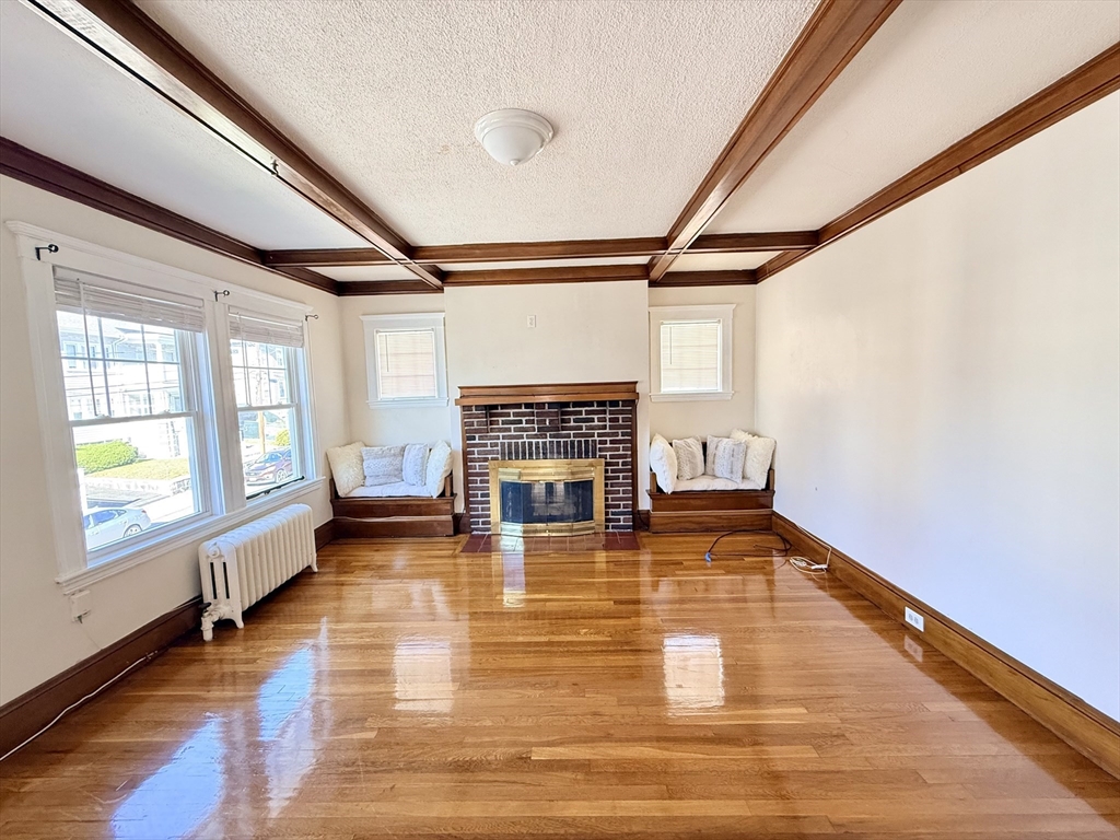 48 Rosewood Street, Unit 2 Boston, MA 02126 - Photo 2 of 26 a living room with a fireplace furniture and a large window