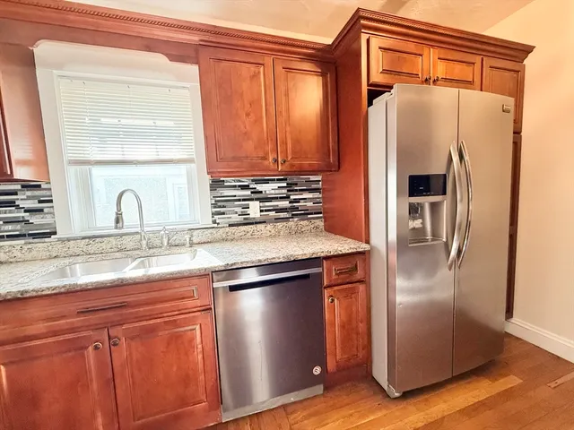 a kitchen with stainless steel appliances granite countertop a refrigerator and a sink