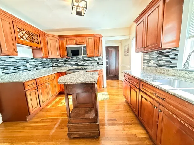 a kitchen with stainless steel appliances granite countertop a stove a sink and a microwave