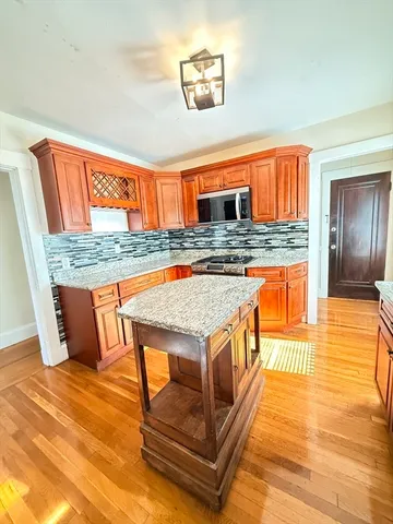 a kitchen with stainless steel appliances granite countertop a stove and a wooden cabinets