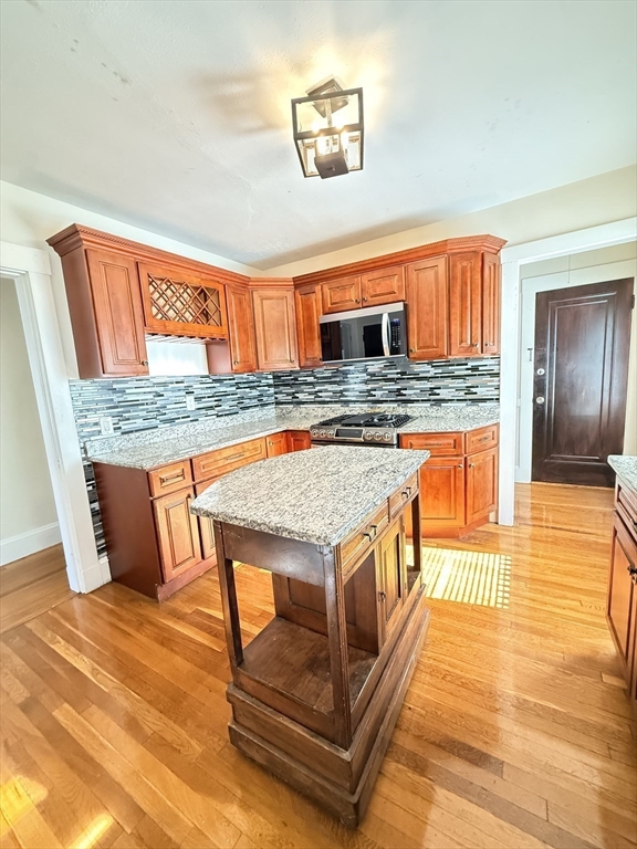 48 Rosewood Street, Unit 2 Boston, MA 02126 - Photo 5 of 26 a kitchen with stainless steel appliances granite countertop a stove and a wooden cabinets
