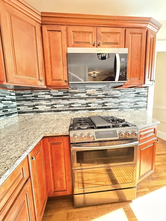 48 Rosewood Street, Unit 2 Boston, MA 02126 - Photo 6 of 26 a bathroom with granite countertop a sink and a stove