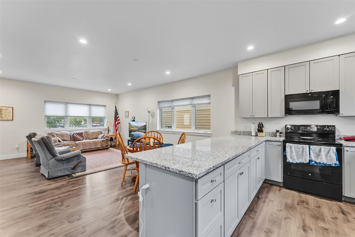 83 Ermine Road, Unit 3A Dillon, CO 80435 - Photo 11 of 33 a open kitchen with stainless steel appliances granite countertop a stove top oven a sink dishwasher a dining table and chairs with wooden floor