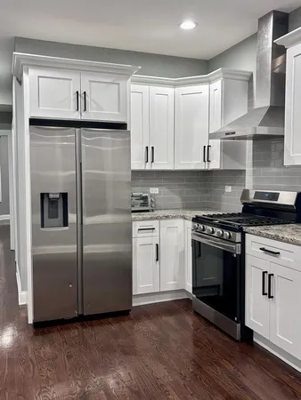 a kitchen with white cabinets and stainless steel appliances