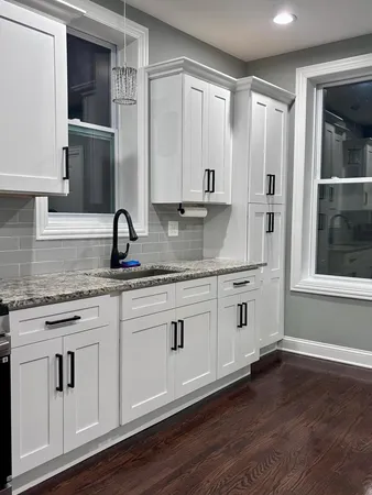 a kitchen with stainless steel appliances granite countertop a sink and a granite counter tops with wooden floors