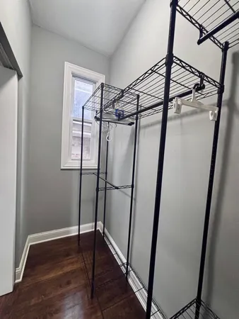 a view of walk in closet with wooden floor and window
