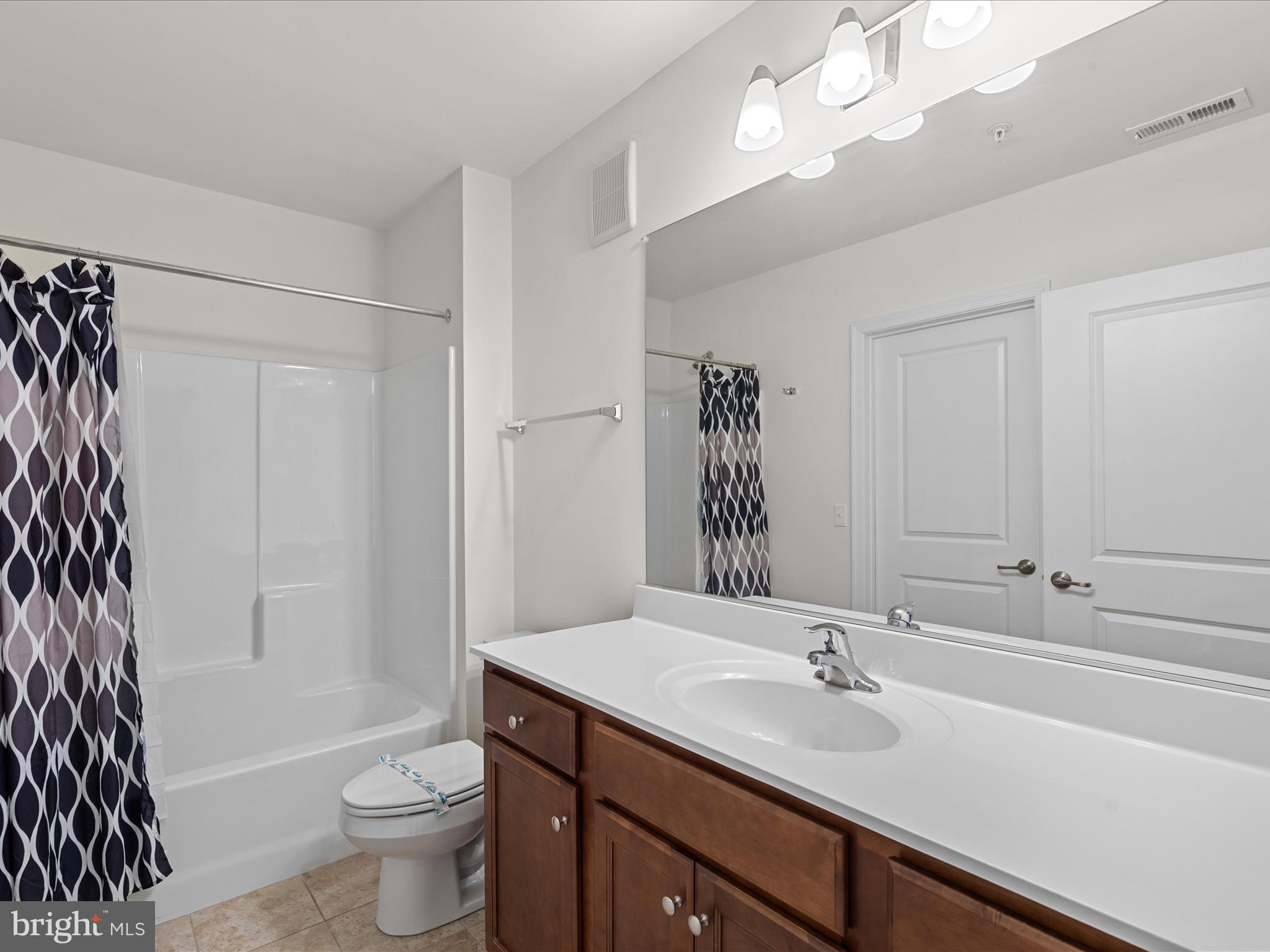 24258 Zinfandel Lane, Unit R303 Lewes, DE 19958 - Photo 29 of 82 a bathroom with a sink a toilet and a large mirror