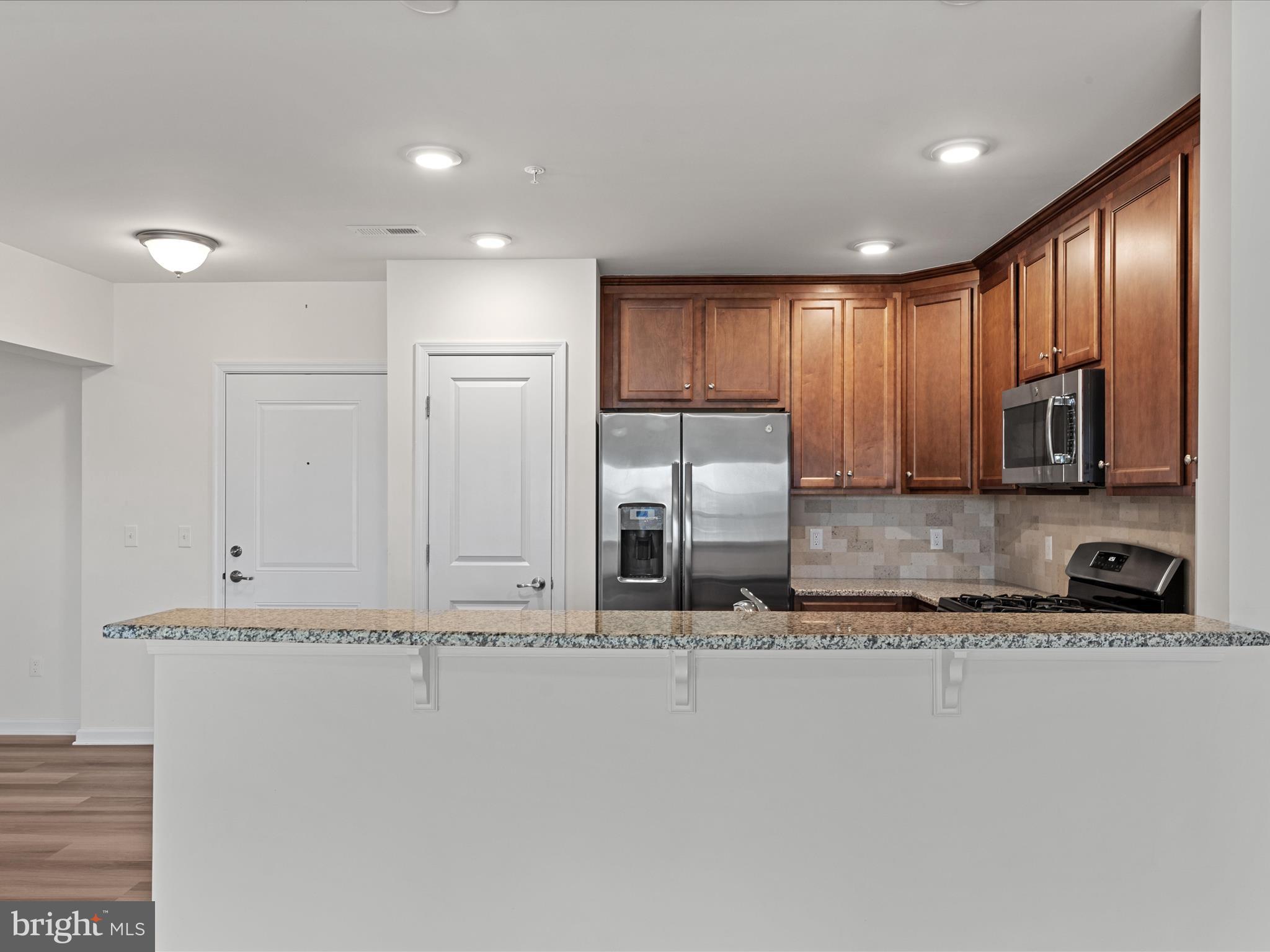 24258 Zinfandel Lane, Unit R303 Lewes, DE 19958 - Photo 35 of 82 a view of a kitchen with stainless steel appliances granite countertop a stove a sink and a microwave