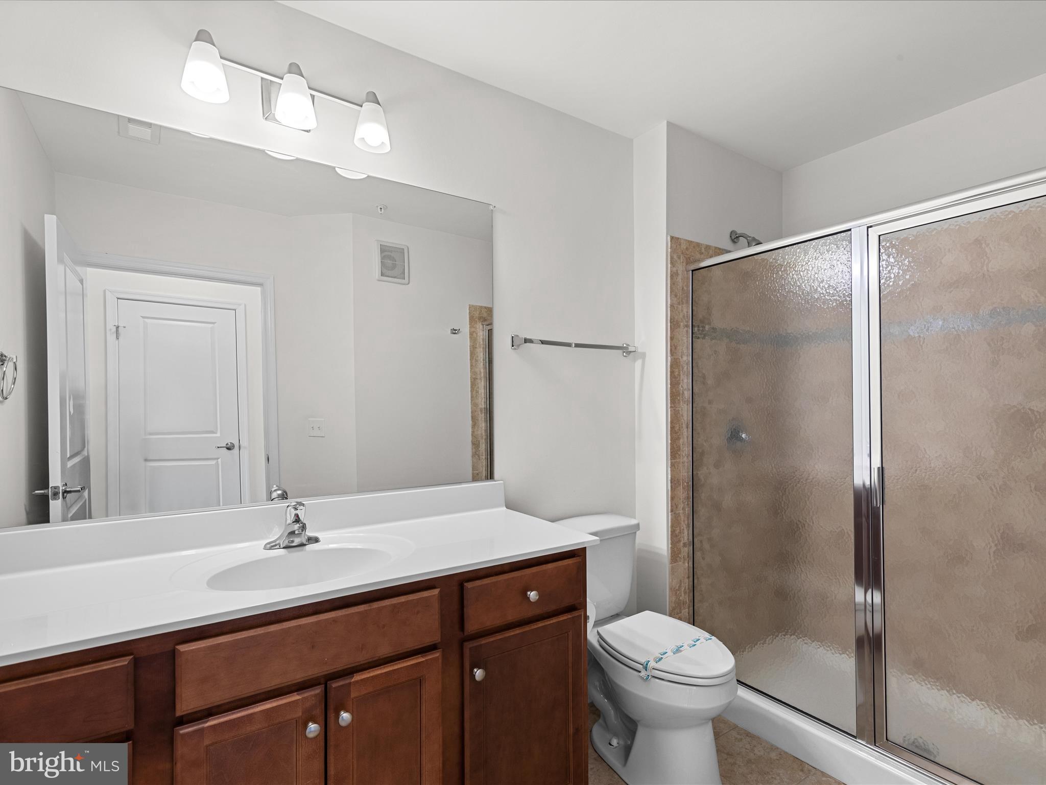 24258 Zinfandel Lane, Unit R303 Lewes, DE 19958 - Photo 40 of 82 a bathroom with a sink a toilet a mirror and shower