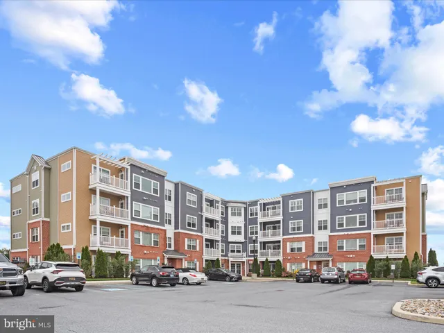 a sign board with a big yard and large trees