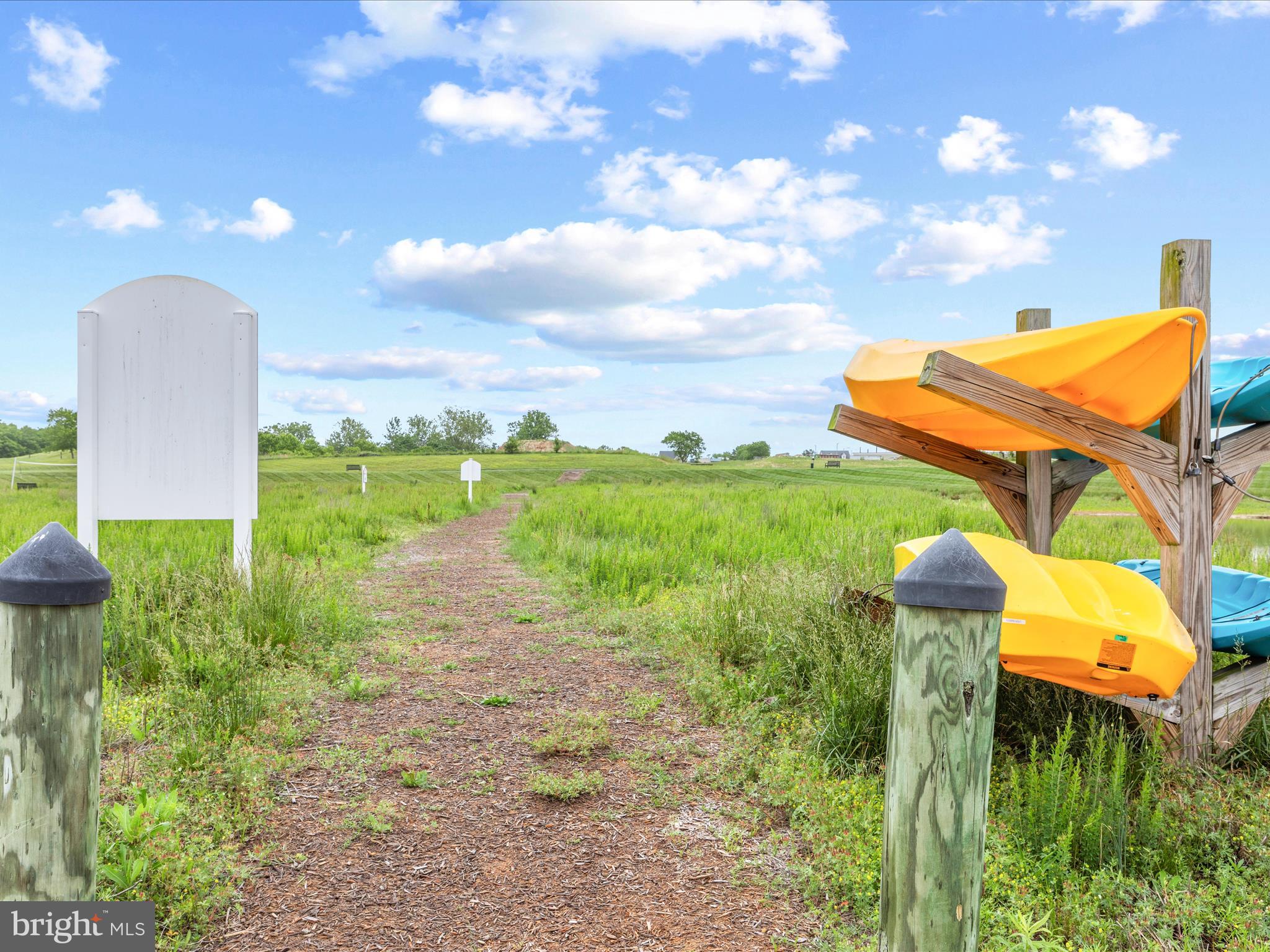 24258 Zinfandel Lane, Unit R303 Lewes, DE 19958 - Photo 76 of 82 a backyard of a house with table and chairs plants and large tree