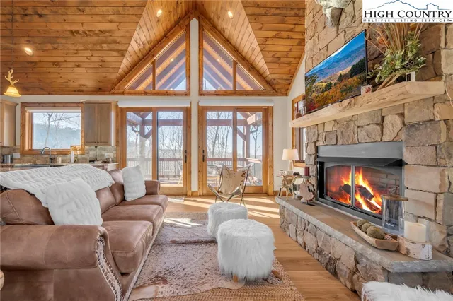 a living room with furniture wooden floor and a kitchen view