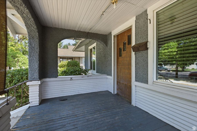342 North 100 West Logan, UT 84321 - Photo 4 of 23 Covered front porch featuring white horizontal siding, dark composite flooring, white beadboard ceiling with recessed lighting, and stone-clad support columns