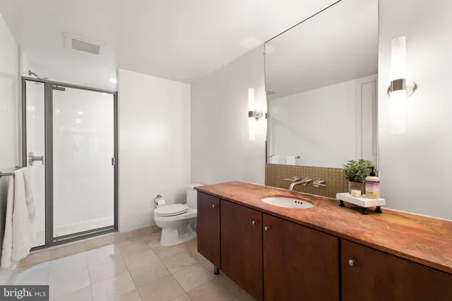 a bathroom with a granite countertop sink toilet and shower