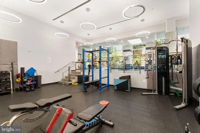 a gym room with gym equipment and a large window