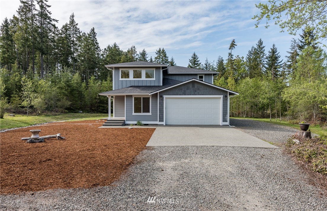 a front view of a house with a yard and trees