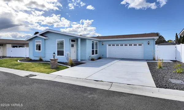 a view of a house with a patio and a yard