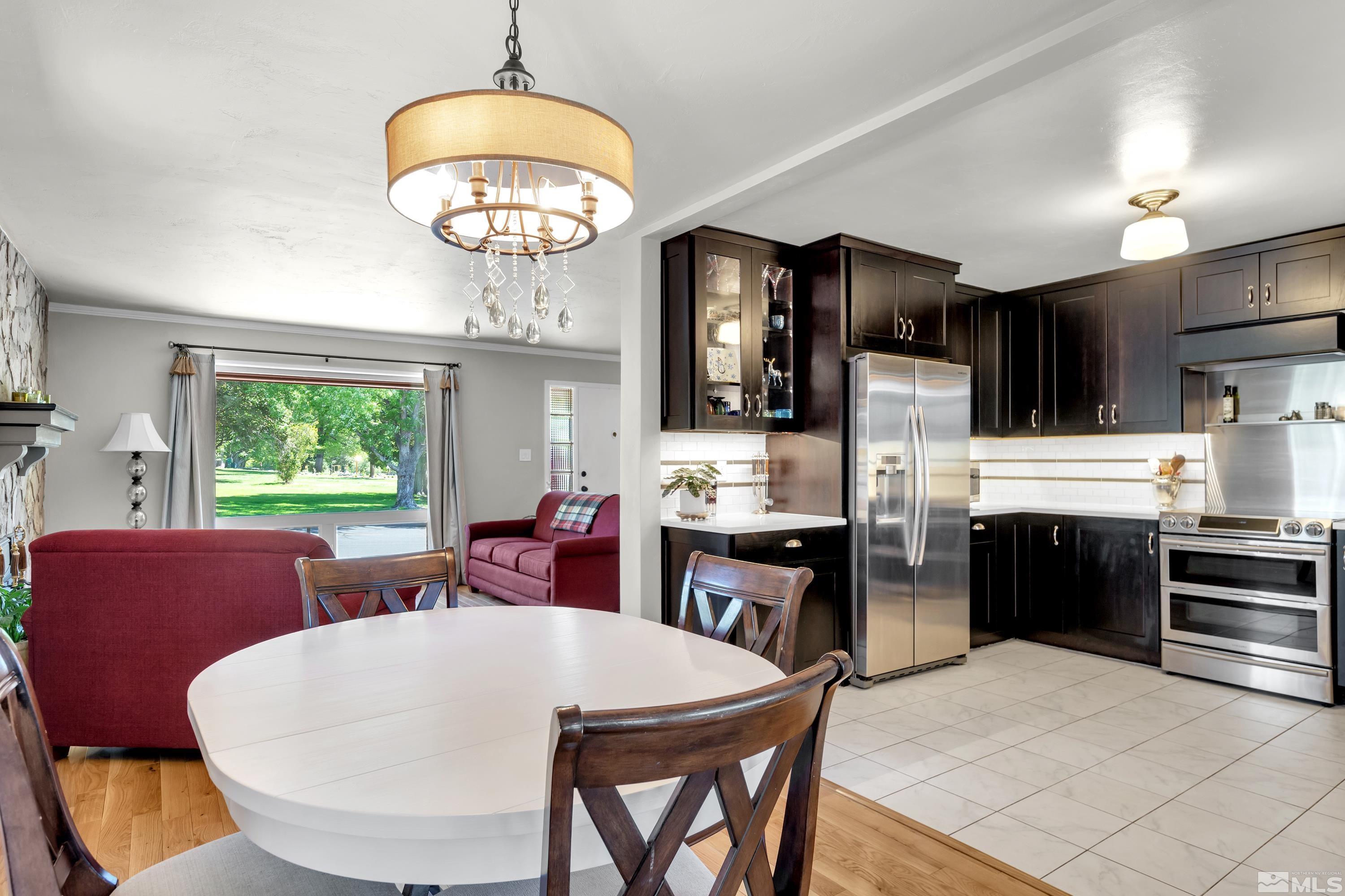 1575 Wesley Drive Reno, NV 89503 - Photo 12 of 40 a large kitchen with stainless steel appliances granite countertop a stove a refrigerator a microwave oven a dining table and chairs with the large window