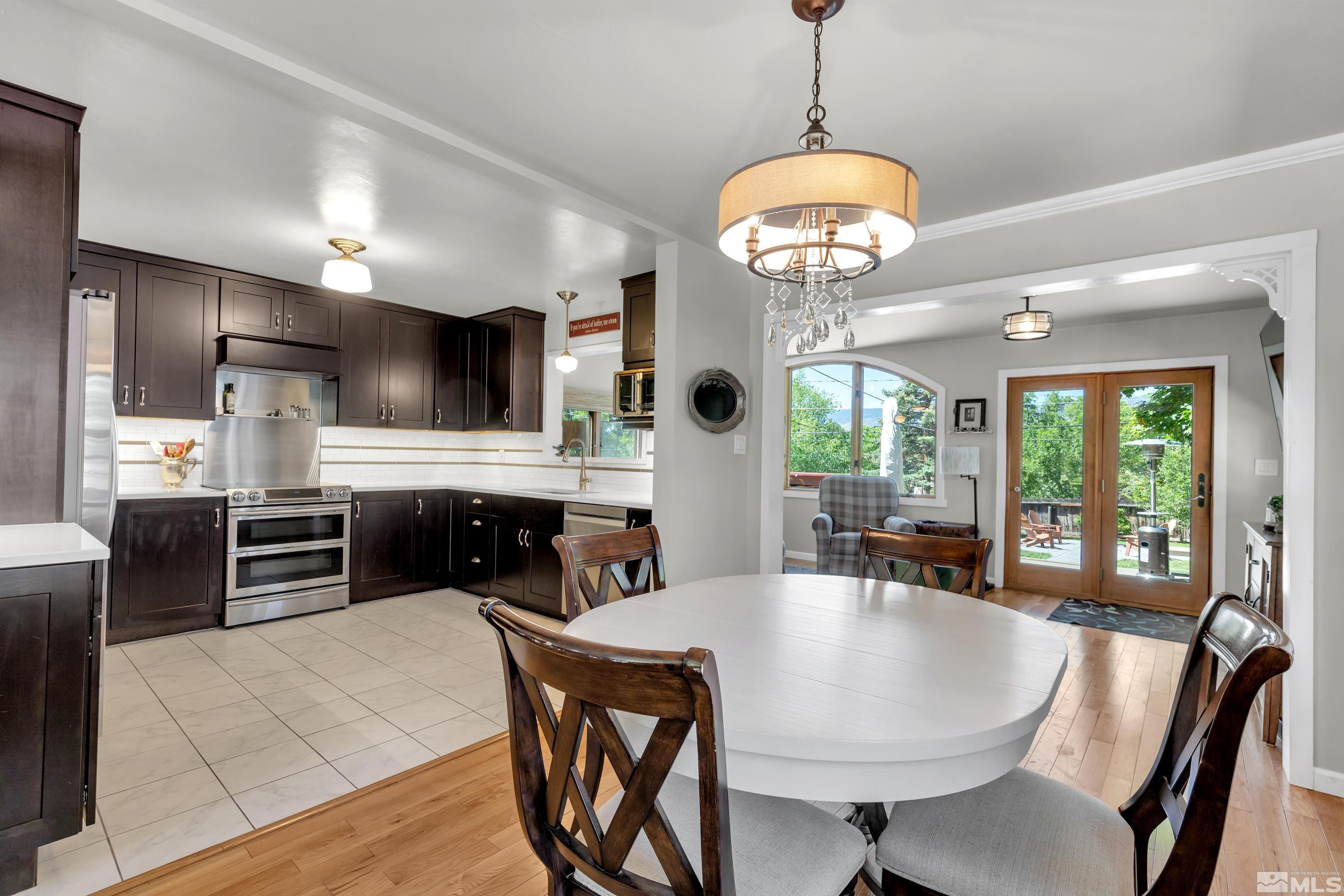 1575 Wesley Drive Reno, NV 89503 - Photo 9 of 40 a kitchen with kitchen island granite countertop a stove a refrigerator a oven a sink a dining table and chairs with wooden floor
